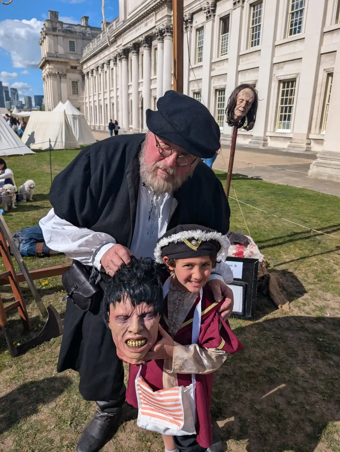 A Tudor executioner reenactor posing with a young visitor